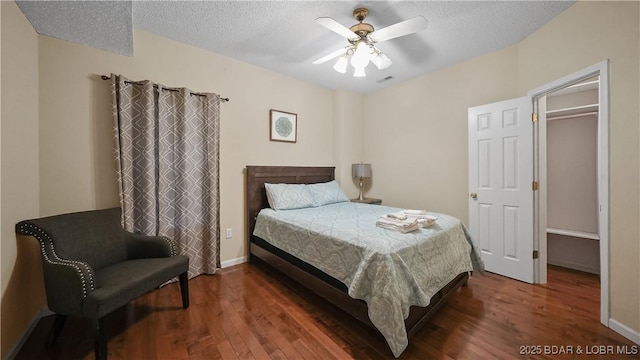 bedroom with wood finished floors, baseboards, and a textured ceiling