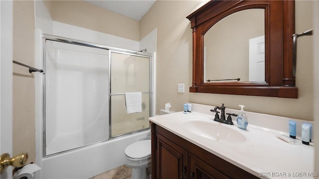 bathroom featuring vanity, toilet, and bath / shower combo with glass door