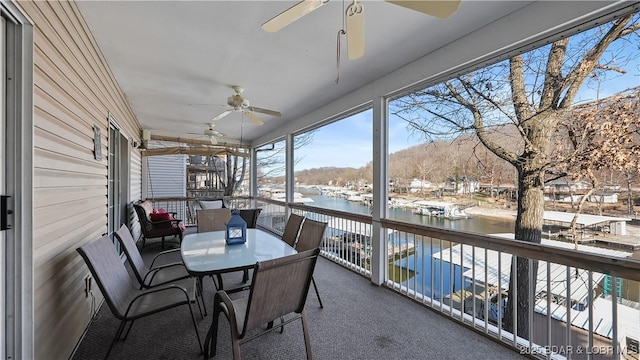 sunroom / solarium with a water view and ceiling fan