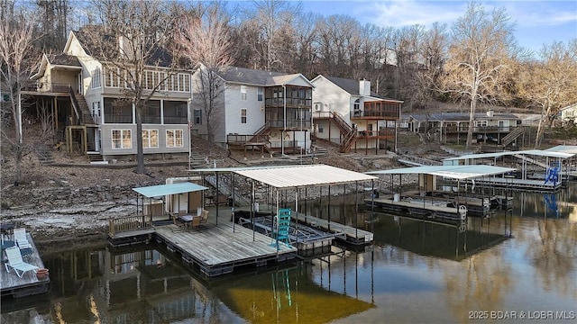 dock area with stairs, a water view, a residential view, and boat lift