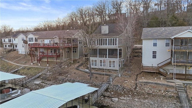 rear view of house featuring stairs, a deck, a residential view, and a sunroom