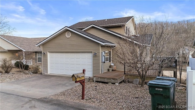 view of front of home with a garage, roof with shingles, a wooden deck, and driveway