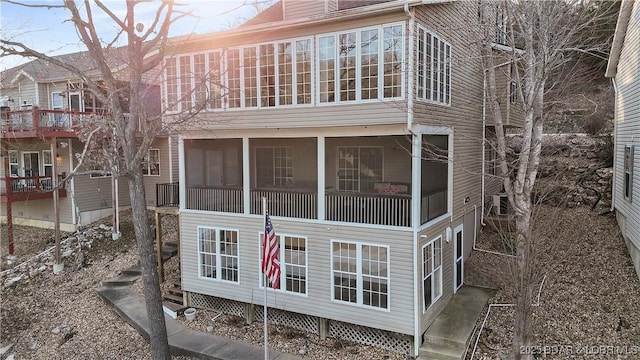 rear view of house featuring a chimney and a sunroom