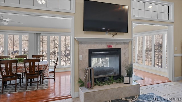 interior space featuring a fireplace, a ceiling fan, and baseboards