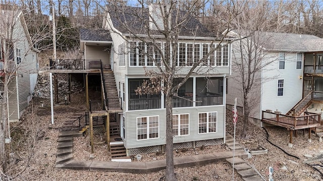 rear view of property featuring stairs and a sunroom