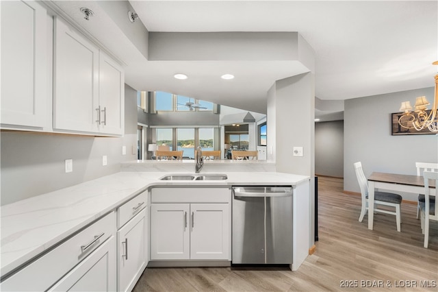 kitchen featuring dishwasher, white cabinets, light wood finished floors, and a sink