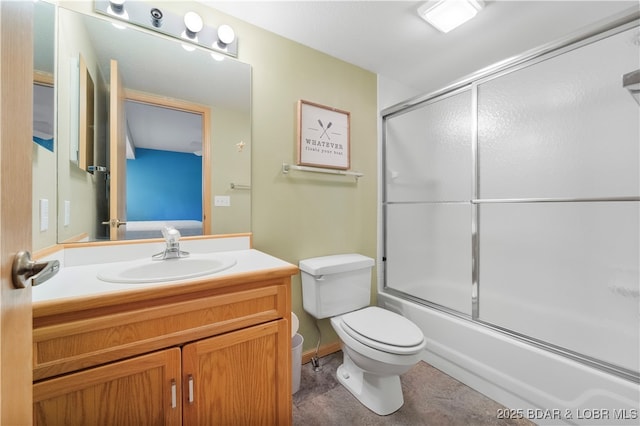 bathroom with vanity, toilet, and combined bath / shower with glass door