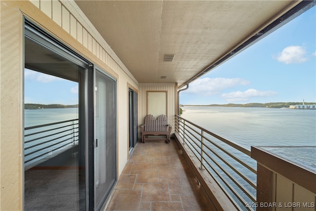 balcony featuring visible vents and a water view