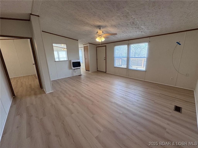 unfurnished living room featuring heating unit, light wood-type flooring, crown molding, and a ceiling fan