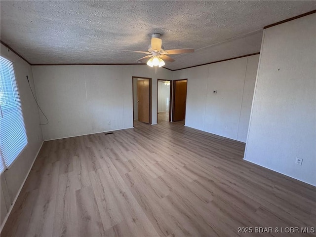 spare room featuring a textured ceiling, crown molding, a ceiling fan, and wood finished floors