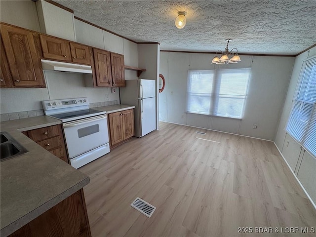 kitchen featuring under cabinet range hood, visible vents, white appliances, and crown molding