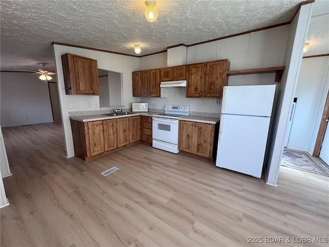 kitchen with light wood-style flooring, a sink, white appliances, crown molding, and light countertops