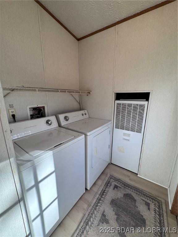 clothes washing area with laundry area, independent washer and dryer, and a textured ceiling