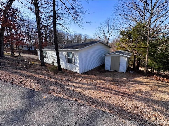 view of side of property with an outbuilding and a storage shed