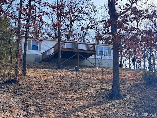 back of property featuring stairs and a wooden deck