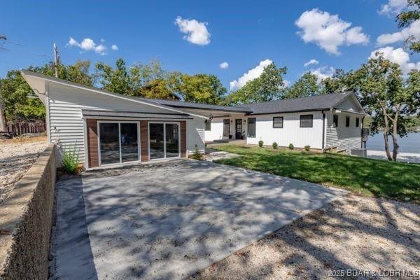 back of property with a yard and a patio area