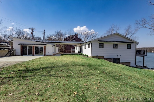 rear view of property featuring a yard and central AC unit