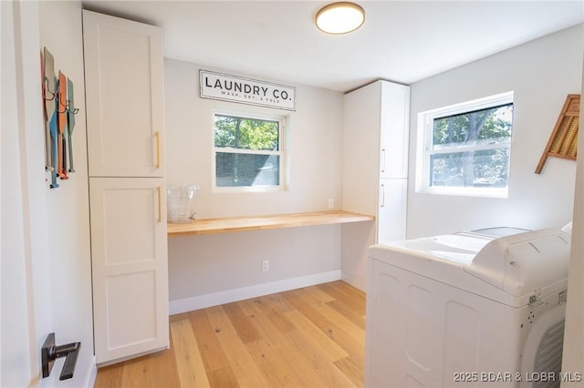 washroom featuring baseboards, cabinet space, light wood-type flooring, and a healthy amount of sunlight