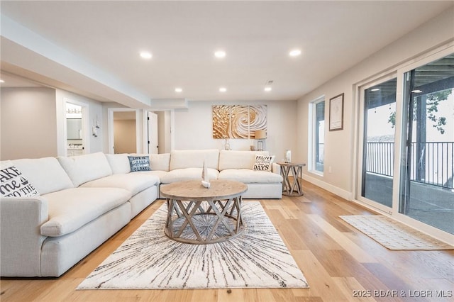 living area with recessed lighting, light wood-style floors, and baseboards