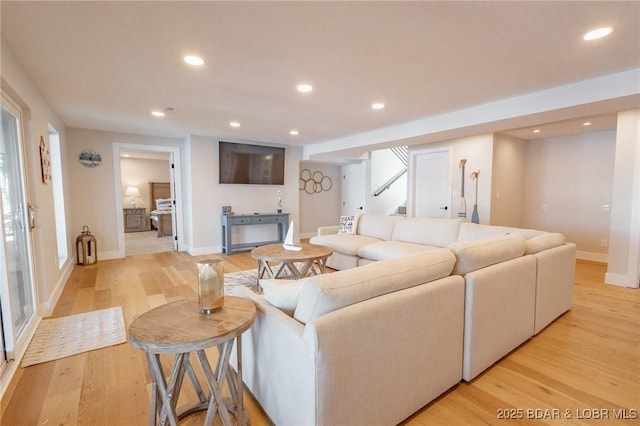 living area featuring light wood finished floors, recessed lighting, stairs, and baseboards