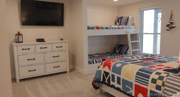 bedroom featuring baseboards and light carpet