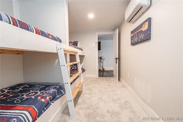 carpeted bedroom featuring baseboards and a wall mounted AC