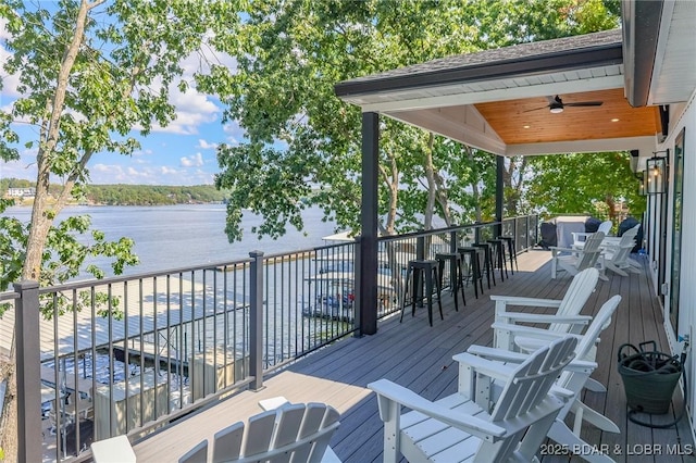 wooden deck featuring a water view and a ceiling fan