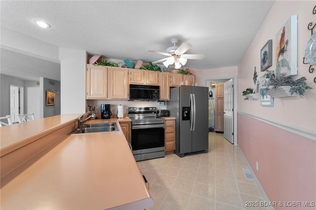 kitchen featuring light brown cabinetry, light countertops, appliances with stainless steel finishes, a ceiling fan, and a sink