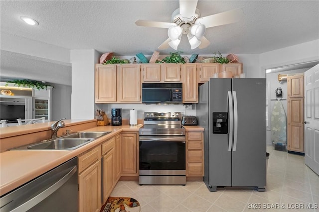 kitchen with light brown cabinetry, a sink, stainless steel appliances, light countertops, and light tile patterned floors