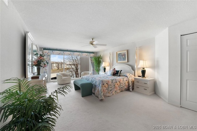 carpeted bedroom with access to exterior, baseboards, a textured ceiling, and a ceiling fan