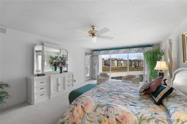 carpeted bedroom with access to exterior, a ceiling fan, and a textured ceiling