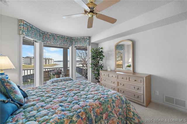 carpeted bedroom featuring ceiling fan, access to outside, visible vents, and a textured ceiling