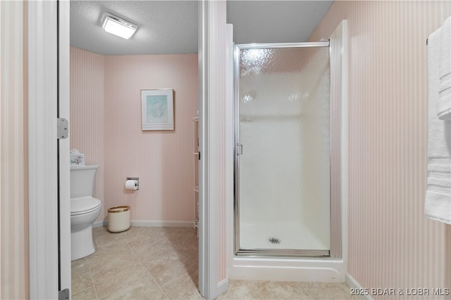 full bathroom with baseboards, a stall shower, tile patterned flooring, a textured ceiling, and toilet