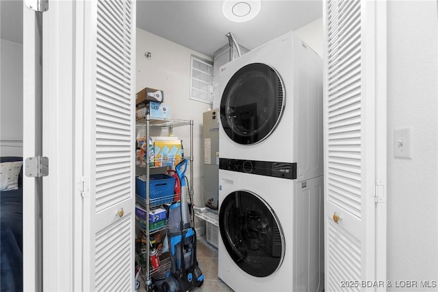 washroom featuring tile patterned flooring, laundry area, and stacked washer / dryer