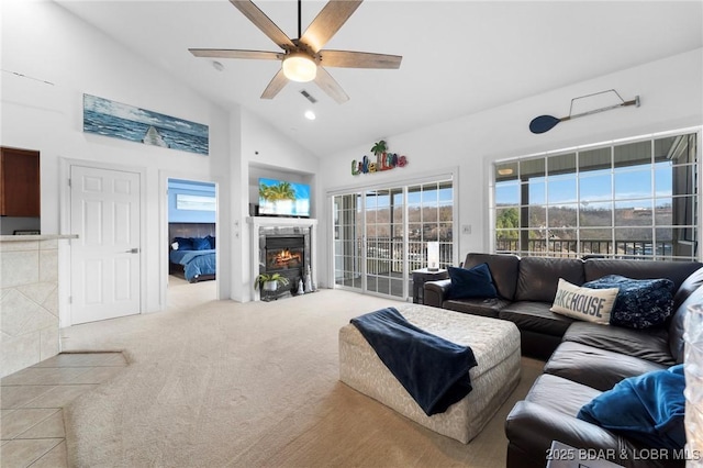 living room featuring visible vents, carpet, ceiling fan, a fireplace, and high vaulted ceiling