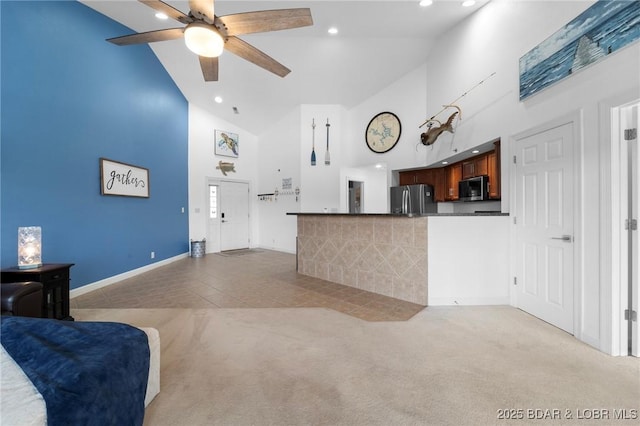 kitchen featuring high vaulted ceiling, dark countertops, stainless steel appliances, light colored carpet, and ceiling fan