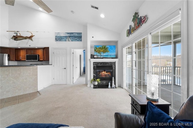 living area with visible vents, a fireplace with flush hearth, light carpet, recessed lighting, and high vaulted ceiling