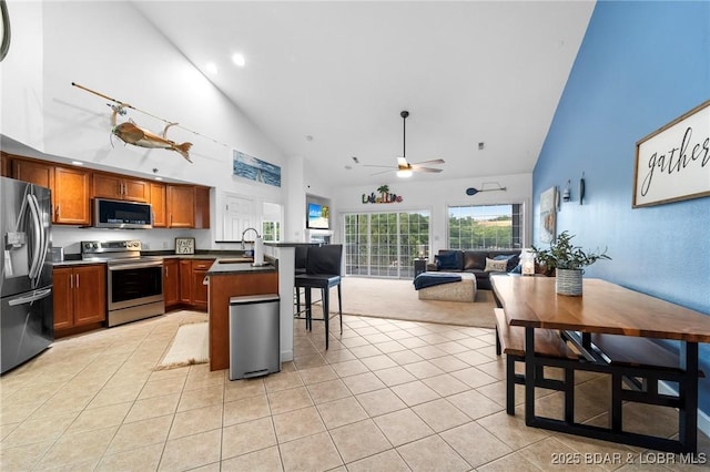 68 Lighthouse Rd Unit 344, Lake Ozark, MO 65049 - kitchen featuring stainless steel appliances, high vaulted ceiling, a peninsula, dark countertops, and light tile patterned floors