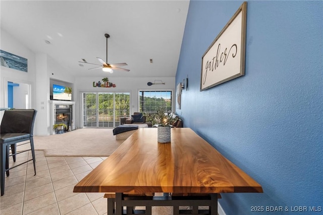 68 Lighthouse Rd Unit 344, Lake Ozark, MO 65049 - dining area featuring a ceiling fan, lofted ceiling, light tile patterned flooring, a glass covered fireplace, and a textured wall
