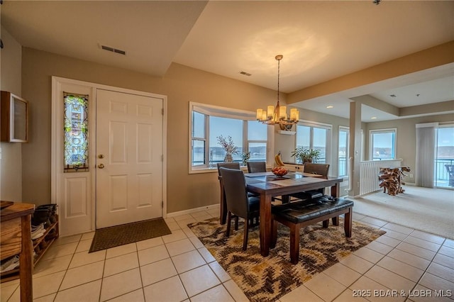 dining area featuring light tile patterned floors, visible vents, and a chandelier