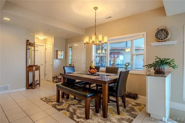 dining area featuring light tile patterned floors, visible vents, baseboards, and a notable chandelier