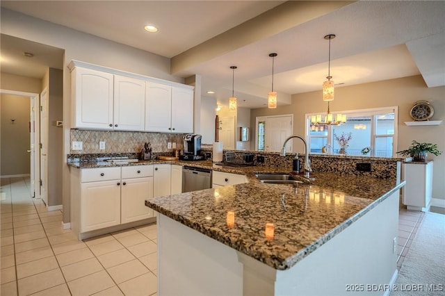 kitchen featuring a sink, tasteful backsplash, white cabinetry, dark stone counters, and dishwasher