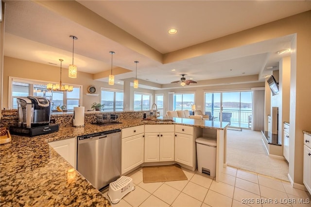 kitchen with light stone countertops, dishwasher, ceiling fan with notable chandelier, white cabinets, and a sink