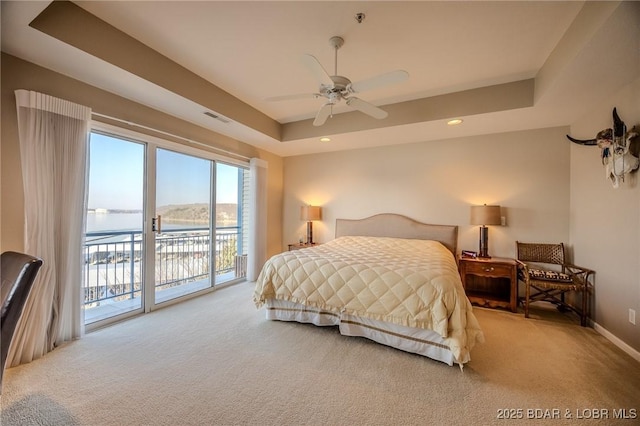 carpeted bedroom featuring visible vents, baseboards, a tray ceiling, recessed lighting, and access to exterior