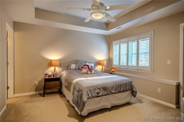 bedroom with a ceiling fan, baseboards, visible vents, light carpet, and a raised ceiling