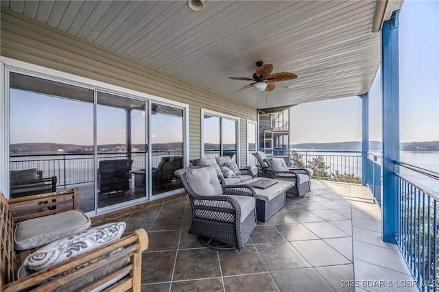 view of patio / terrace featuring a balcony, a ceiling fan, and a water view