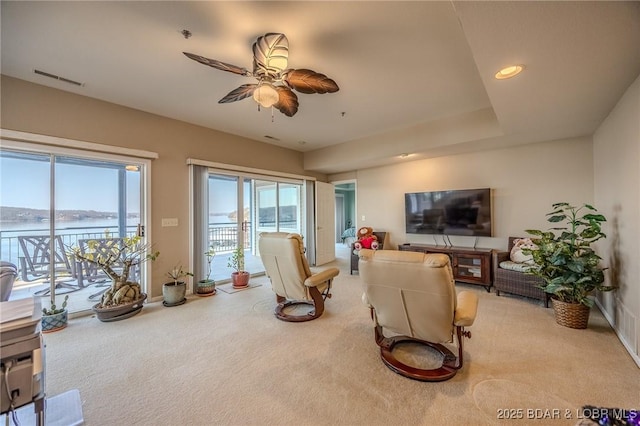 living room featuring visible vents, a ceiling fan, recessed lighting, baseboards, and light colored carpet