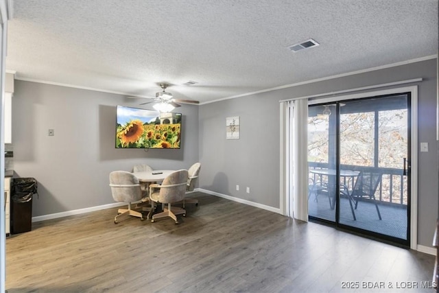 dining space with ceiling fan, visible vents, wood finished floors, and ornamental molding