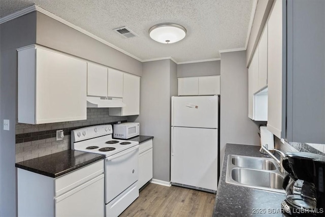 kitchen with white appliances, visible vents, light wood finished floors, a sink, and under cabinet range hood