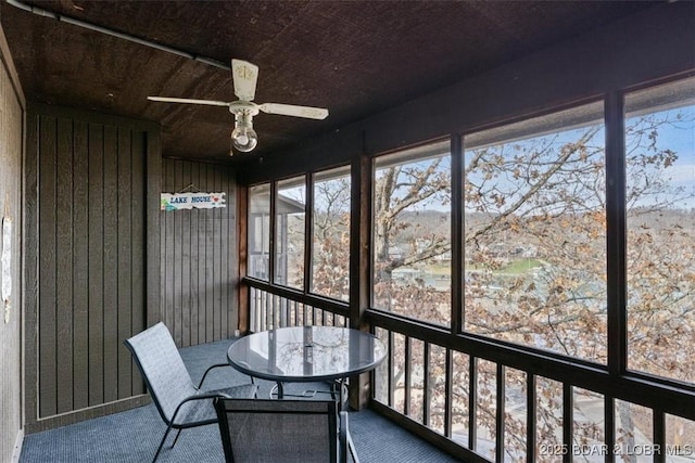 unfurnished sunroom with ceiling fan